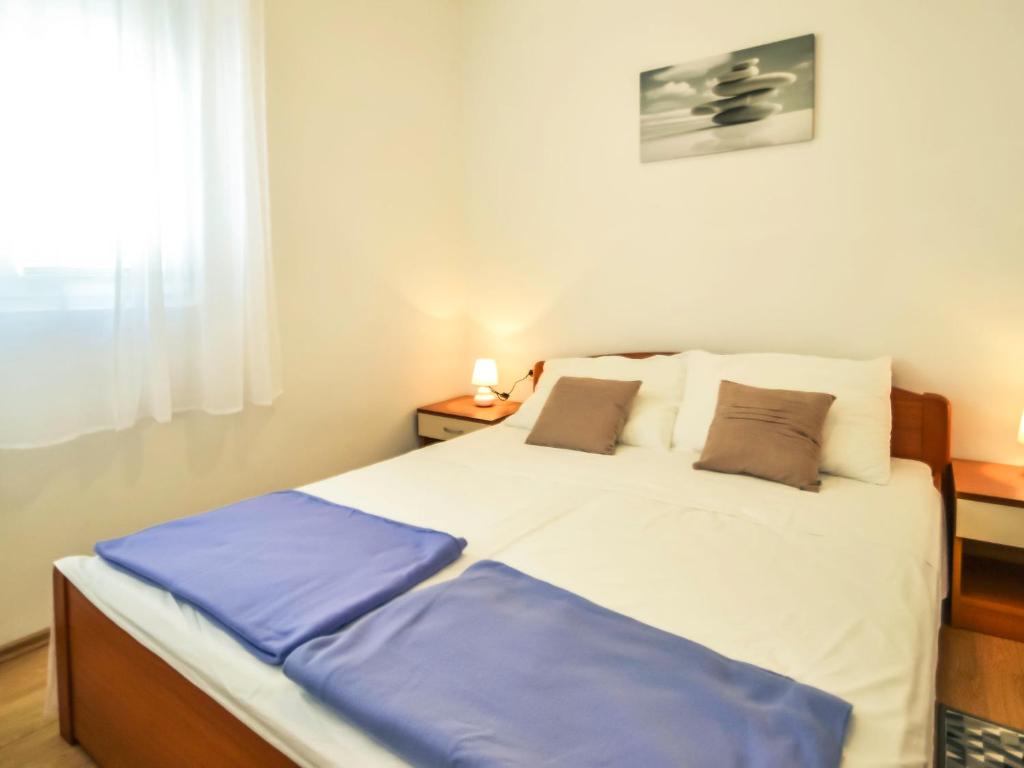 sypialnia z dużym białym łóżkiem z dwiema poduszkami w obiekcie Apartment Dragica-1 by Interhome w mieście Podorjak