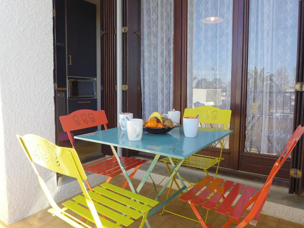 カネ・アン・ルシヨンにあるApartment Les Voiliers by Interhomeのテーブル(椅子付)とフルーツの盛り合わせ