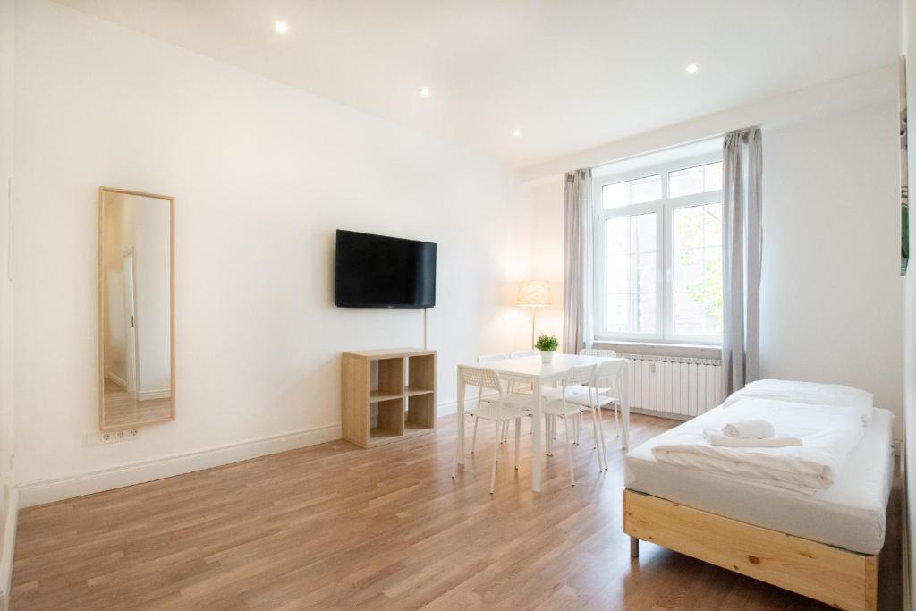 a living room with a bed and a table at RAJ Living - 1 or 3 Room Apartments - 20 Min Messe DUS and Old Town DUS in Düsseldorf