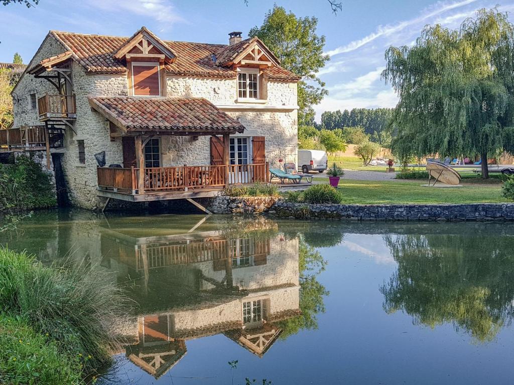a house with a reflection in the water at Holiday Home Moulin de Rabine by Interhome in Cancon