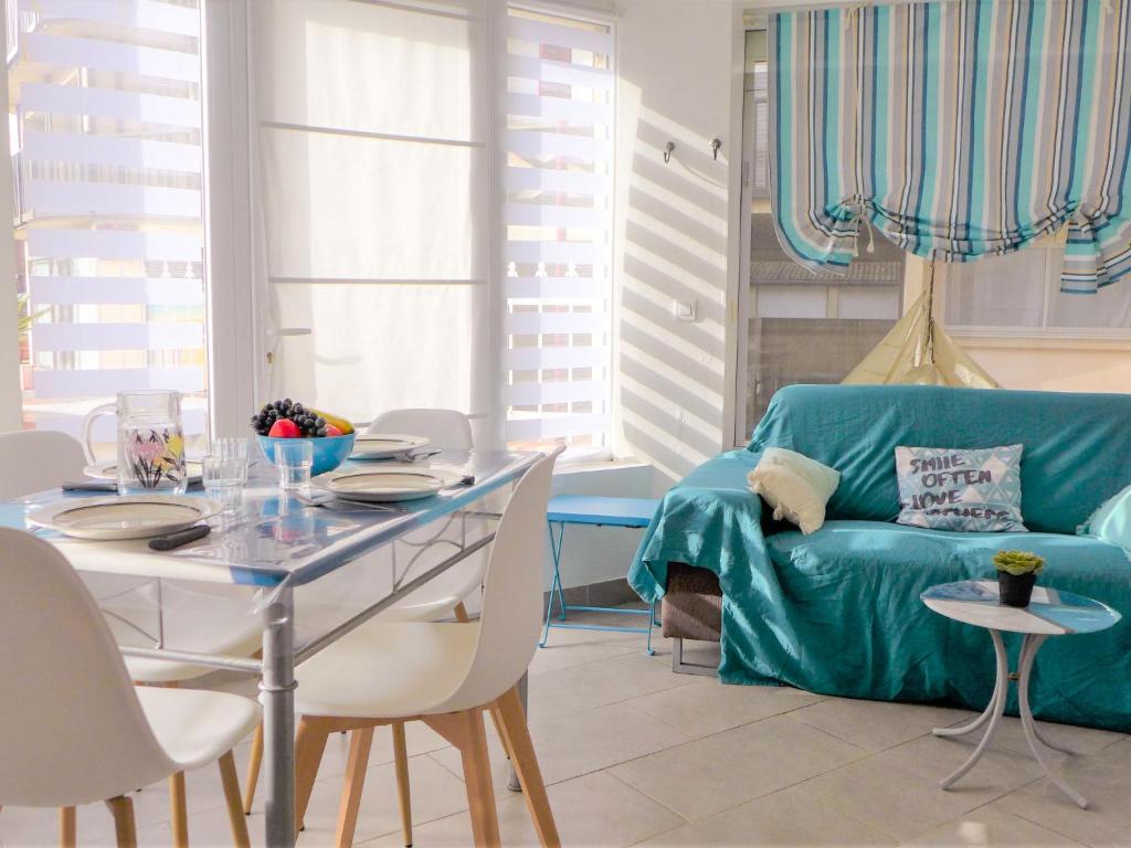 un soggiorno con divano blu e tavolo di Apartment Ô petit bonheur by Interhome a Houlgate