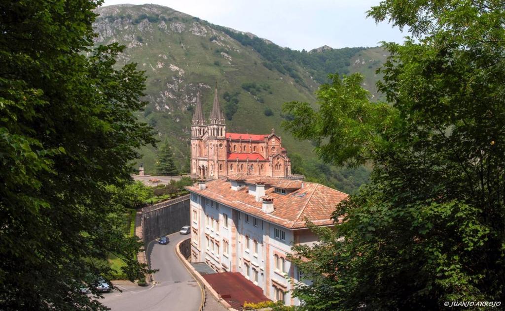 
a large building with a clock on the top of it at Arcea Gran Hotel Pelayo in Covadonga
