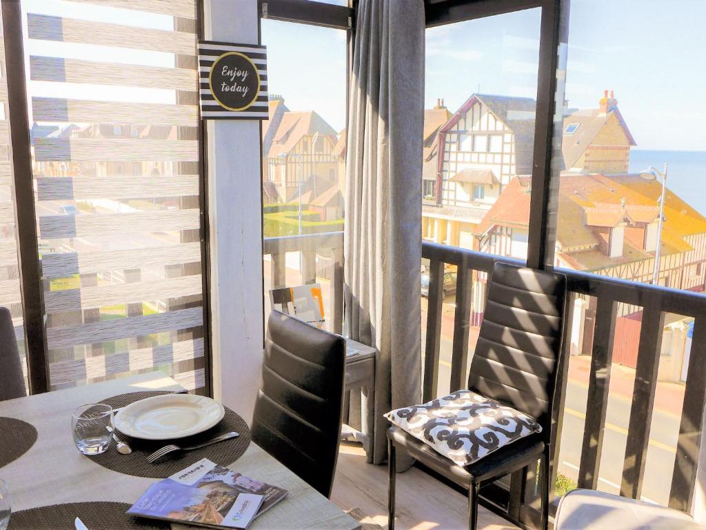un balcon avec une table, des chaises et une fenêtre dans l'établissement Apartment Kennedy by Interhome, à Villers-sur-Mer