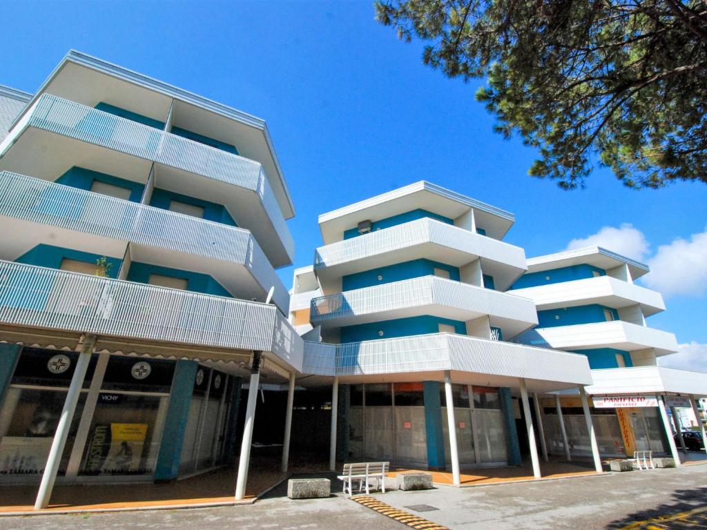 un edificio de apartamentos alto con balcones blancos. en Apartment Simma-12 by Interhome, en Bibione