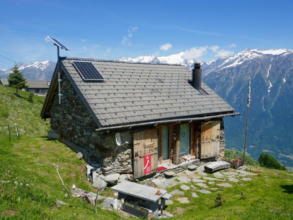 a small house with a solar roof on a mountain at Holiday Home Rustico Hotel Quattro Venti by Interhome in Ardet