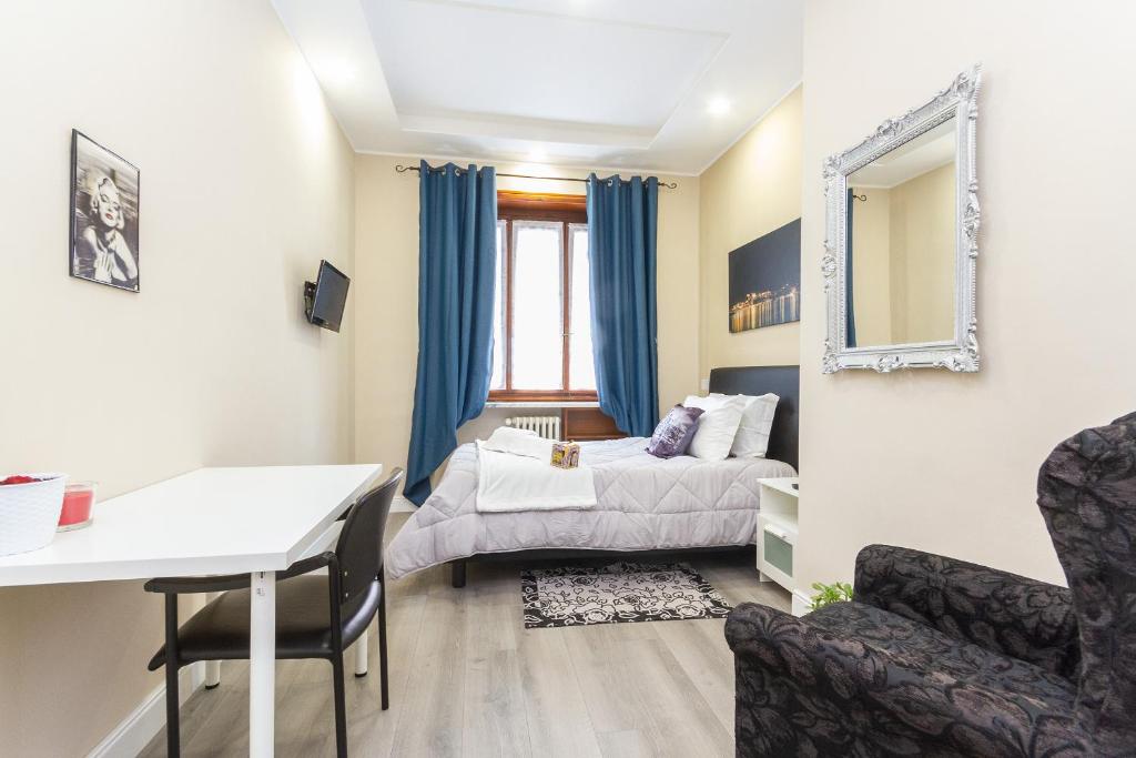 ein Schlafzimmer mit einem Bett, einem Tisch und einem Stuhl in der Unterkunft Exclusive Room Arena Inalpi 'La casa di Bertino' in Turin