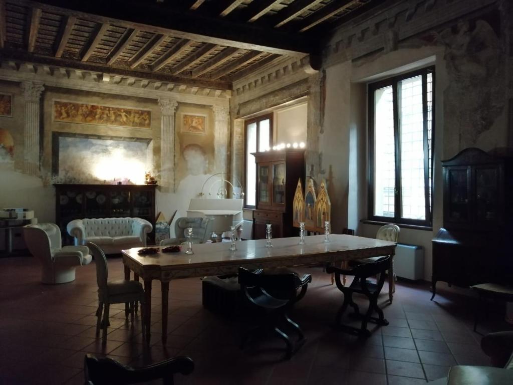 uma sala de jantar com uma grande mesa e cadeiras em Palazzo cinquecentesco con giardino interno em Verona