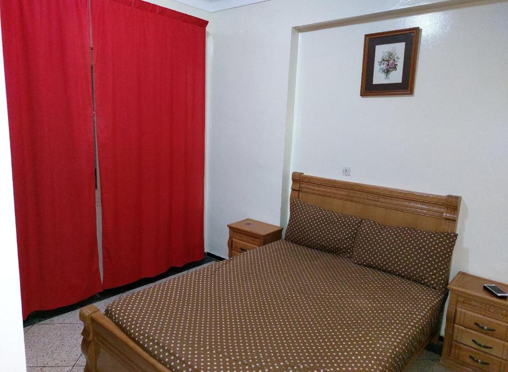 um quarto com uma cama com uma cortina vermelha em Appartement Hamria RiF em Meknès