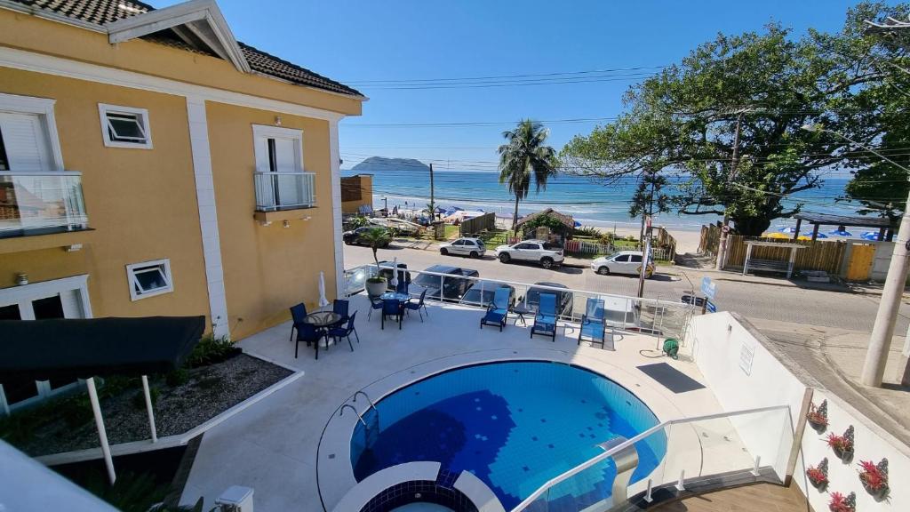a beach with a pool and a balcony at Juquei Frente ao Mar Hotel Pousada in Juquei