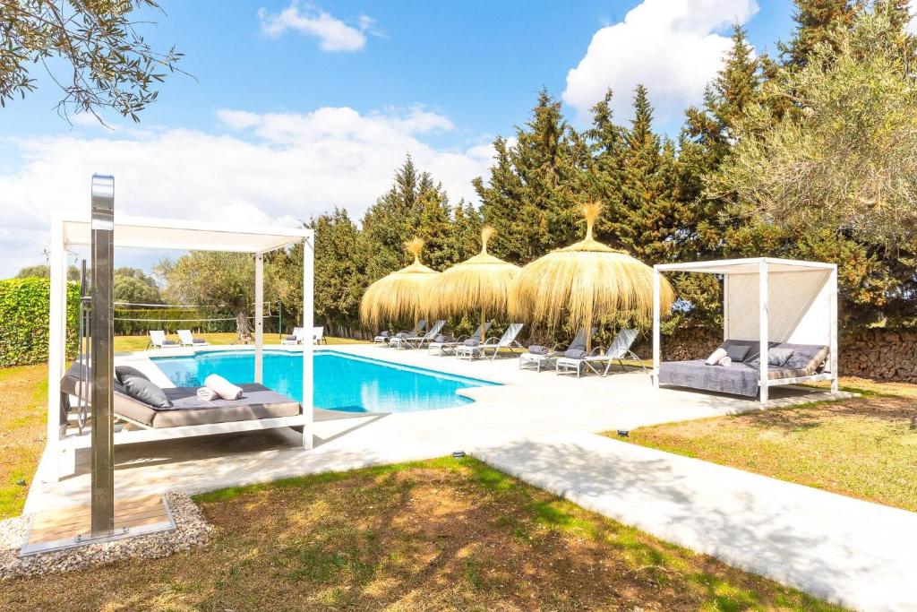 einen Pool mit Stühlen und einem Pavillon in der Unterkunft Can Maties in Santa Margalida