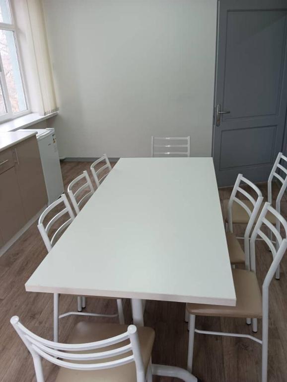 a white table and chairs in a room at BekBro Hostel in Bishkek
