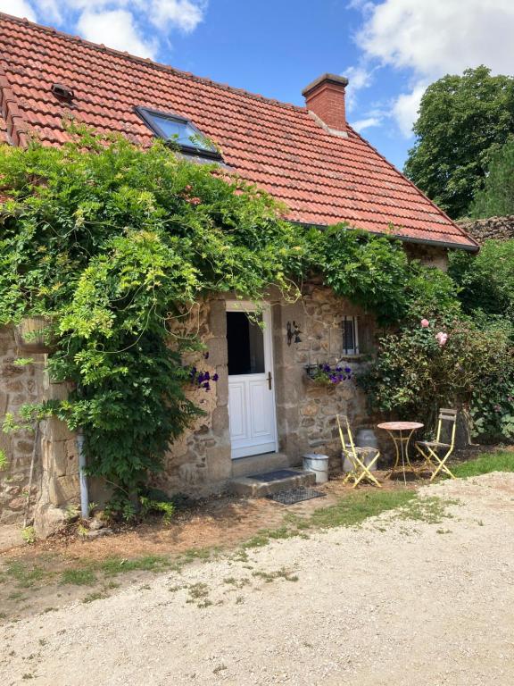a stone cottage with a white door and a table at Domaine de Villateux in Terjat