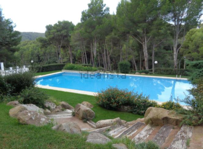 una grande piscina blu in un cortile di Precioso apartamento con piscina en Tamariu a Tamariu