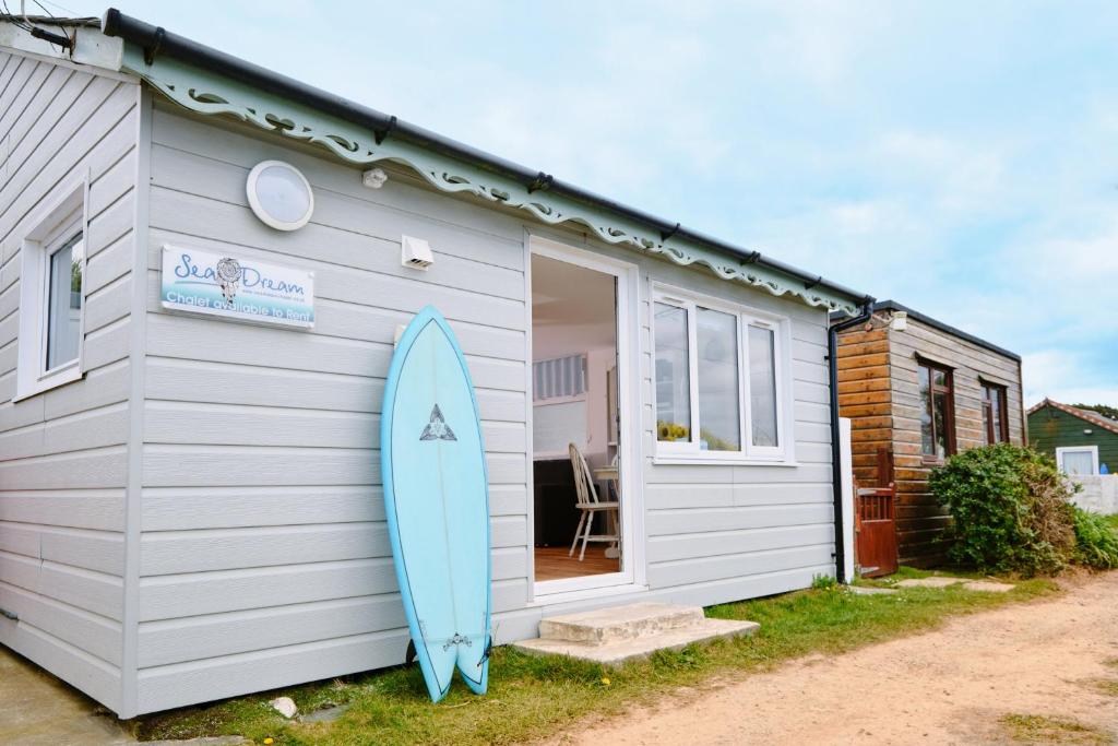 a surfboard is parked outside of a tiny house at Gwithian, Sea Dream Beach Chalet in Gwithian