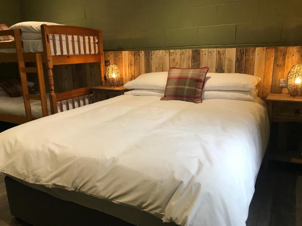 a bedroom with a large bed with white sheets and pillows at Rostrevor Mountain Lodge Hostel Accommodation in Rostrevor