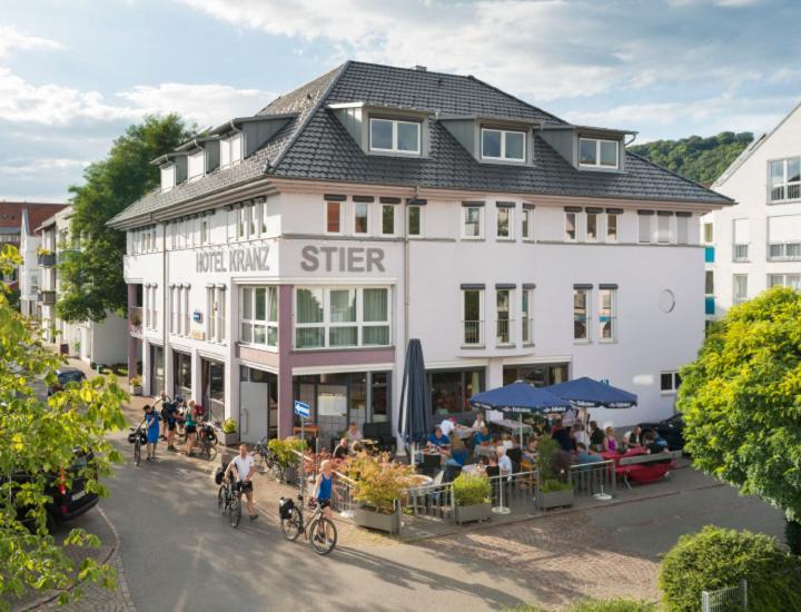 - un grand bâtiment blanc avec des cyclistes devant dans l'établissement Hotel Kranz, à Gottmadingen