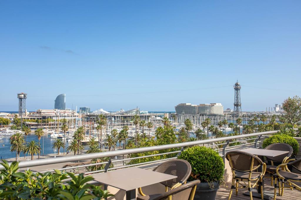 a balcony with tables and chairs and a view of a harbor at Duquesa de Cardona Hotel 4 Sup by Duquessa Hotel Collection in Barcelona