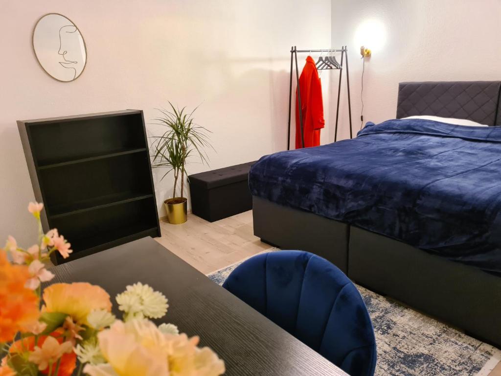 1 dormitorio con cama, mesa y reloj en Theox Apartment No 6 Royal Blue für 4 Personen en Mannheim