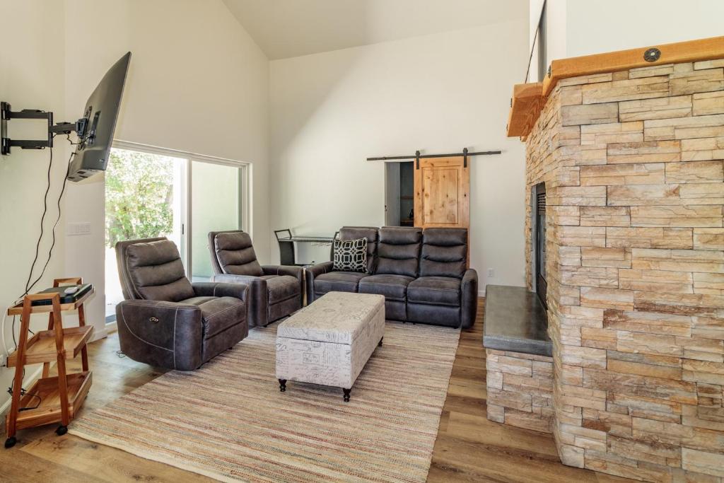 sala de estar con sofás y chimenea de ladrillo en Yosemite Sandy River Retreat, en Oakhurst