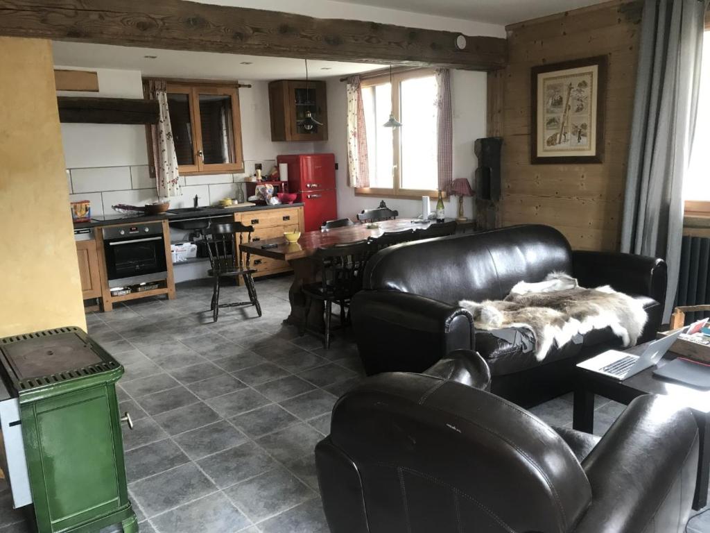 a living room with a leather couch and a table at Le Chalet des Fées in Valmorel