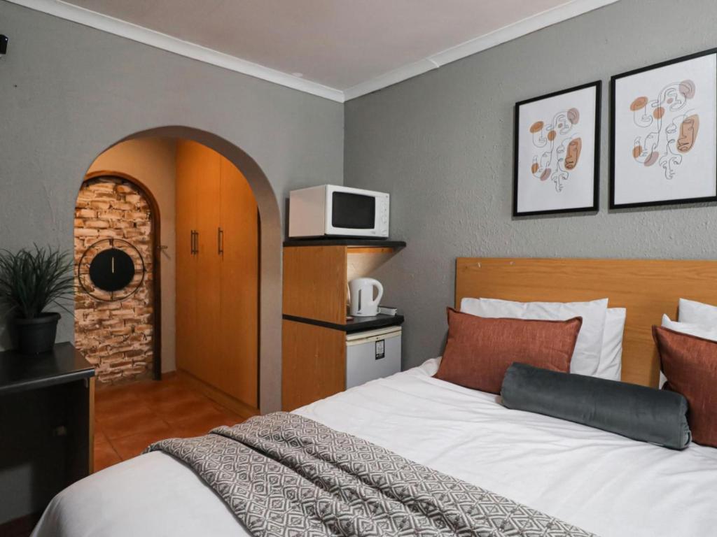 1 dormitorio con 1 cama y TV en la pared en 16 Vaalrivier, en Secunda