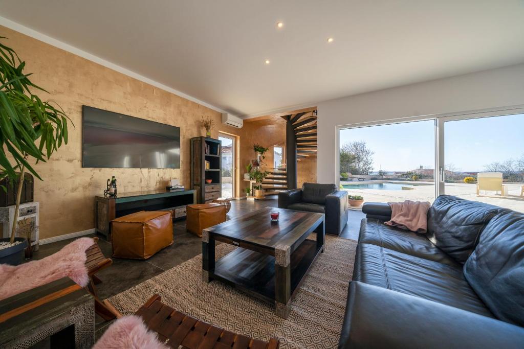 ein Wohnzimmer mit einem Sofa und einem Tisch in der Unterkunft Villa Elani - Stylish And Modern 6B Seaview Villa in Vrsi