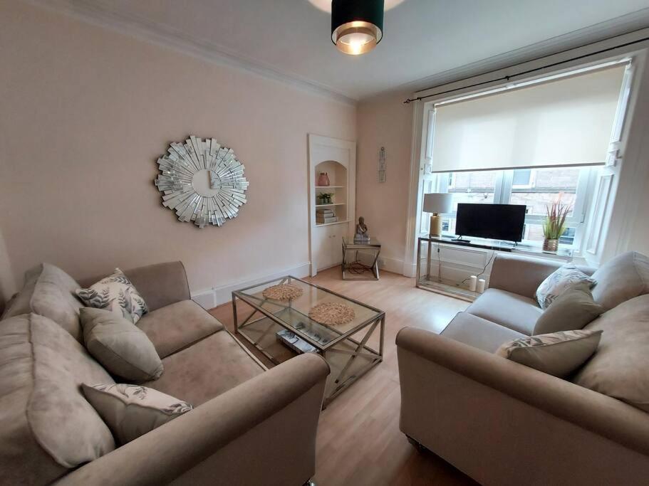 a living room with two couches and a television at Lovely 2 bedroom apartment in the centre of Hawick in Hawick
