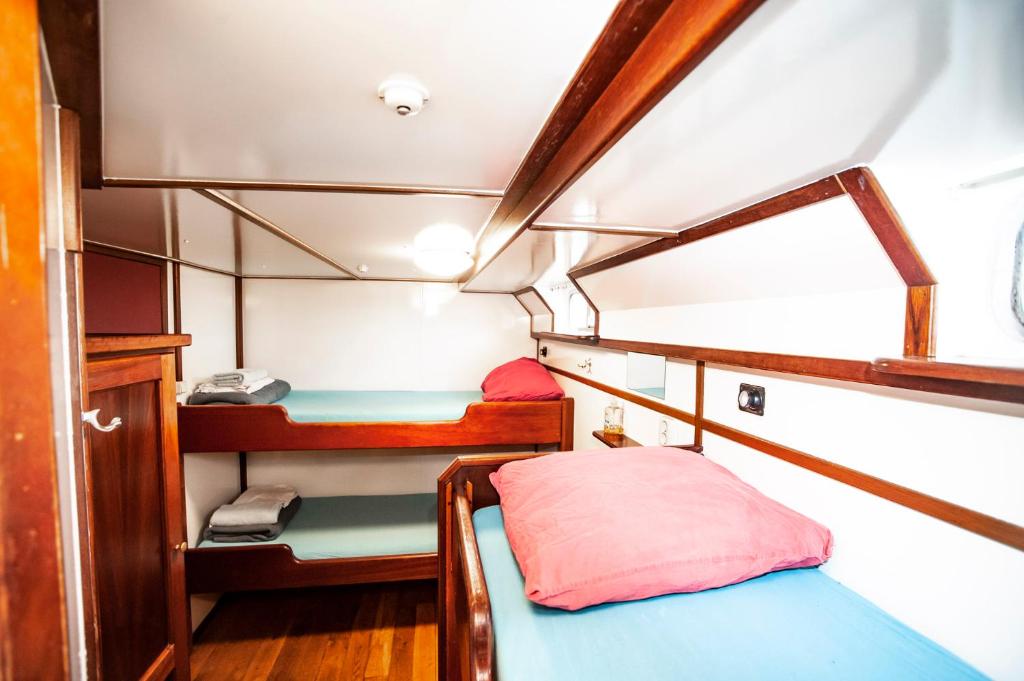 een kleine kamer met 2 bedden in een boot bij Amsterdam Hotelboat in Amsterdam