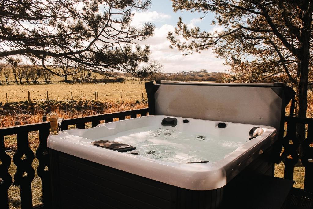 a bath tub sitting on top of a fence at Keer Side Lodge, Luxury lodge with private hot tub at Pine Lake Resort in Carnforth