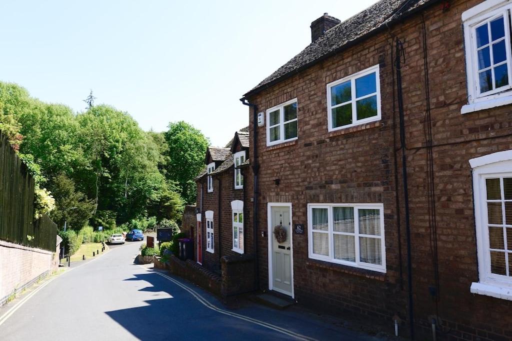 a brick house with a white door on a street at Victoria Cottage, Ironbridge in Ironbridge