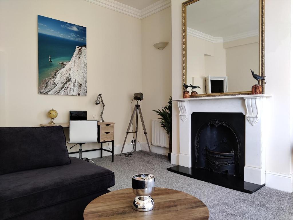 a living room with a couch and a fireplace at 6 Queens Gardens in Eastbourne