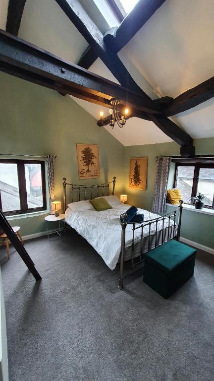 a bedroom with a bed in a room with windows at Log Burner 3 double bedroom very cosy in Kendal
