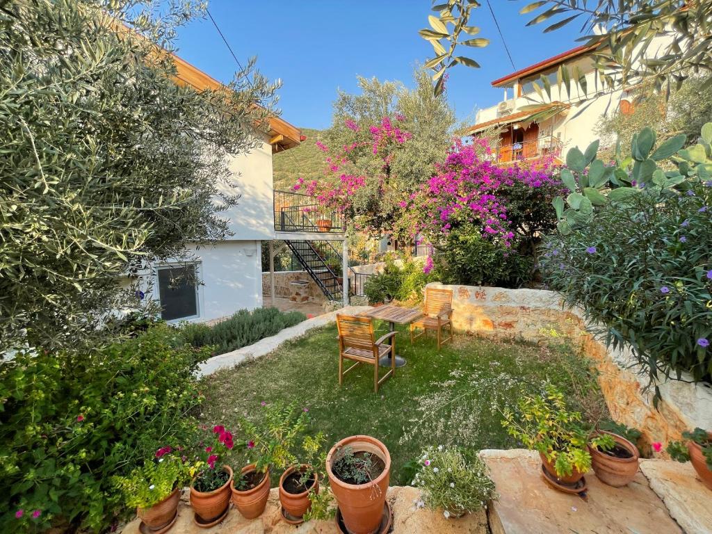 a garden with potted plants and a chair at Kaktus Beach Apart in Kaş