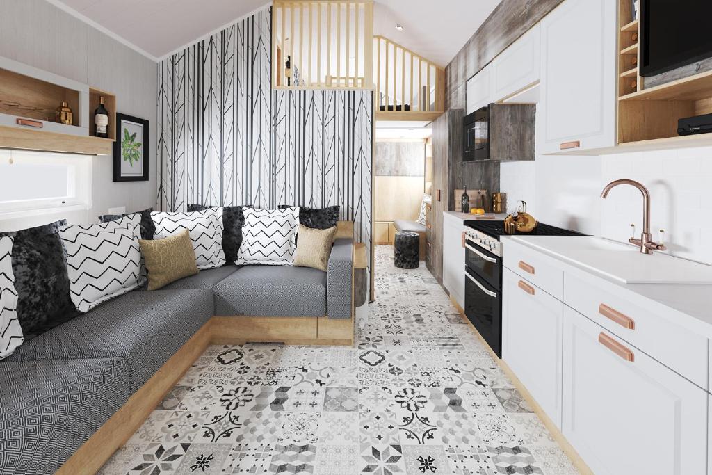 uma pequena cozinha com um sofá e um lavatório em The Parr Pod - Beautiful, luxury pod em Aberlour