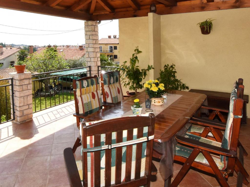 a wooden table and chairs on a balcony at Family Rooms Sabrina in Poreč