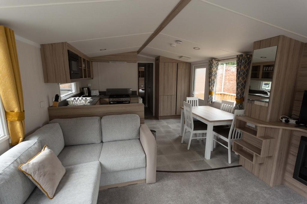 a living room with a couch and a kitchen at The Salmon Van - Beautiful, luxury static caravan in Aberlour