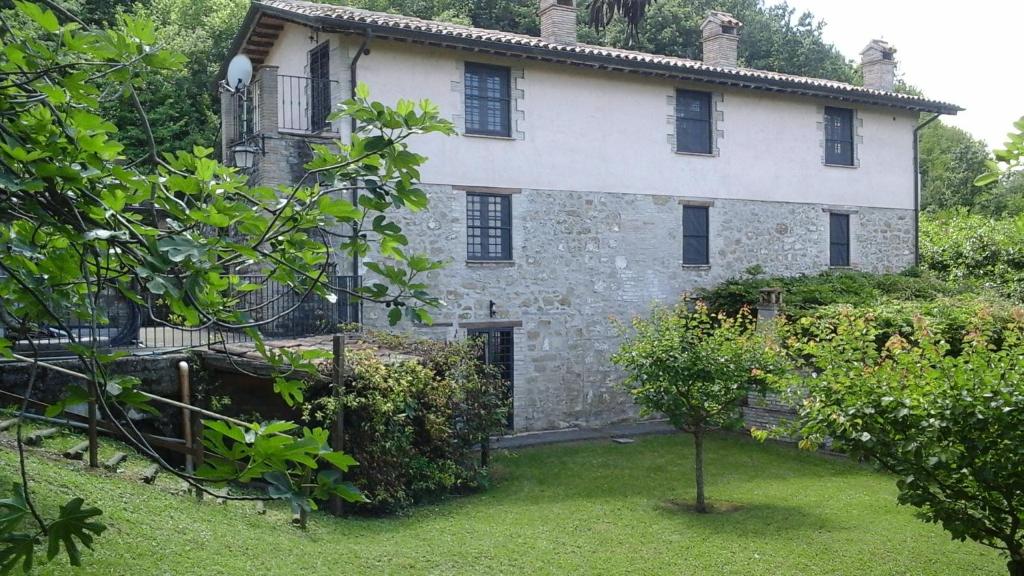an old stone house with a garden in front of it at Charming&Luxury Villa near Assisi, Service Experience Exclusive in Valfabbrica