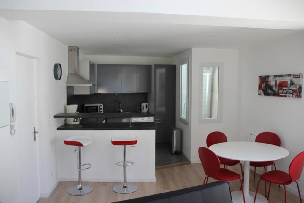 een keuken met rode stoelen en een tafel in een kamer bij 40m All Comfort In Front Of The Old Port in La Rochelle