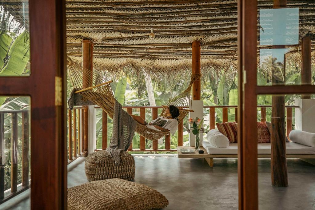 a woman is sitting in a hammock on a porch at Nina Villa in Ahangama