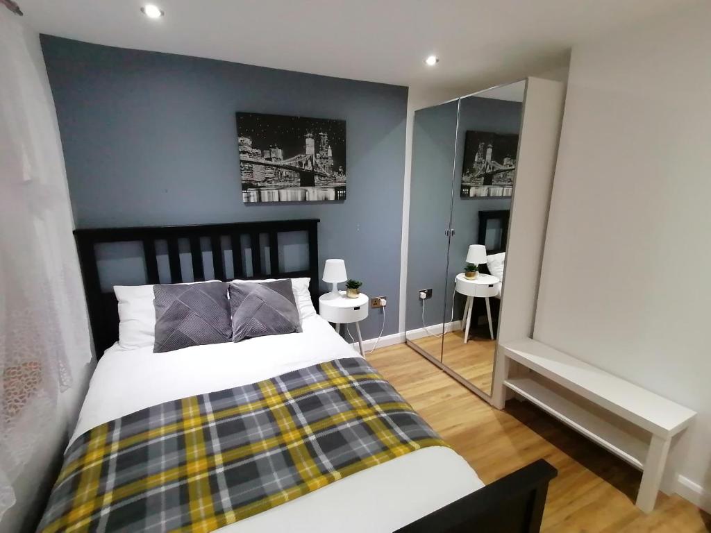 a bedroom with a bed and two tables and a mirror at Lovely 2-Bed Apartment in Coventry in Coventry