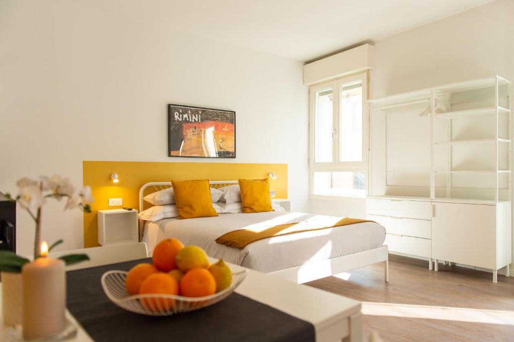 una camera con un letto e un cesto di frutta su un tavolo di Corso51 Suite Apartments a Rimini