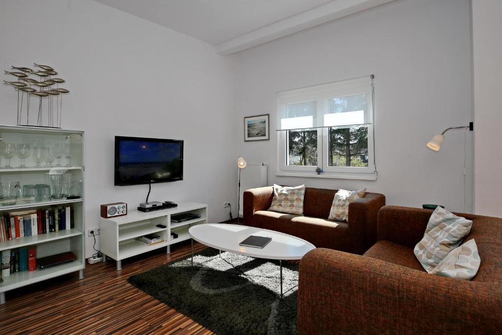 a living room with two couches and a tv at Macoma Baltica Wohnung 04 in Kühlungsborn