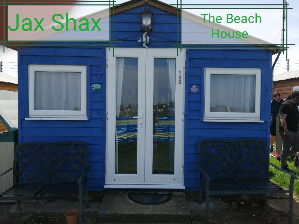 una casa azul con dos sillas delante en The Beach Hut Home from Home in Leysdown on Sea en Sheerness