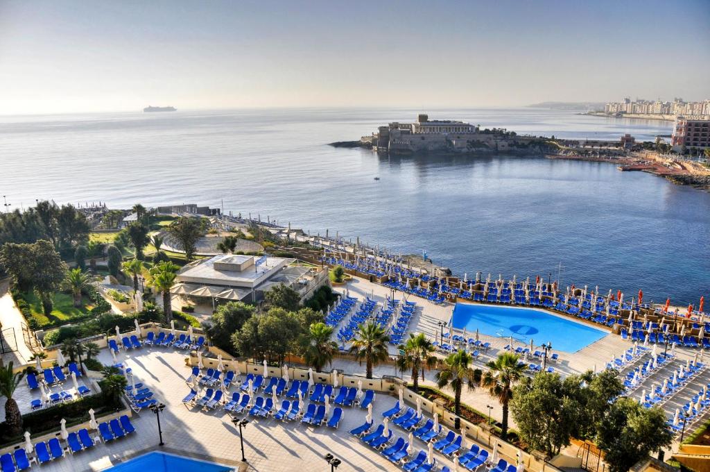 an aerial view of a resort with a pool and the ocean at Corinthia St George's Bay in St. Julianʼs
