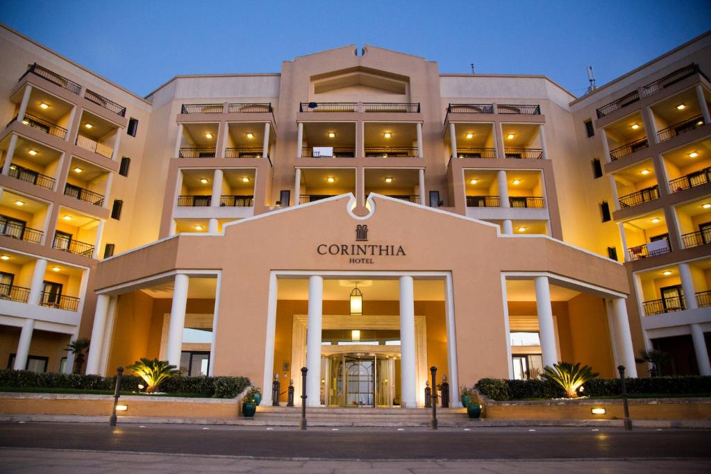 a building with a sign on the front of it at Corinthia St George's Bay in St. Julianʼs
