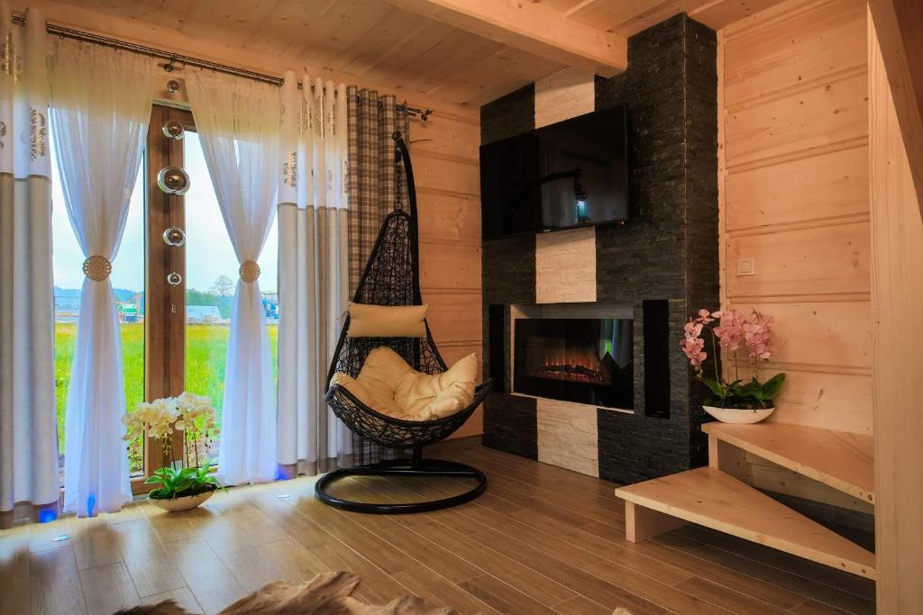 a living room with a hammock and a fireplace at Domek Dream Holiday in Poronin