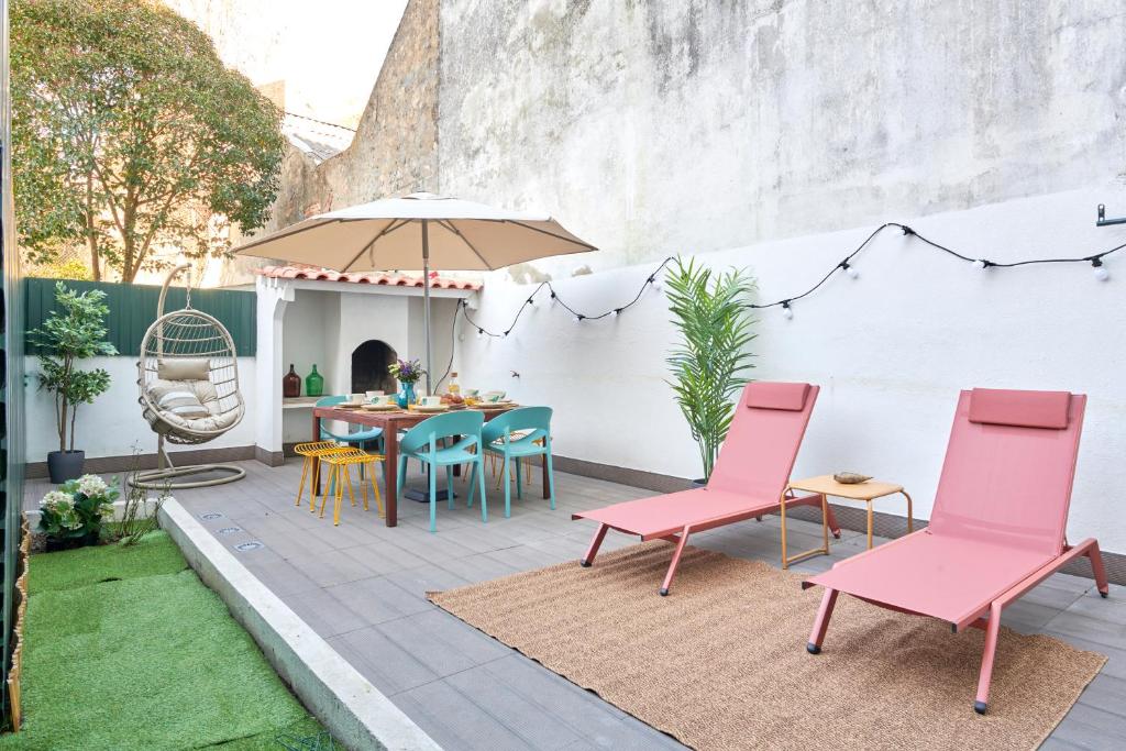 un patio con sillas rosas y una mesa en Charming 3BR APT w/ patio, by TimeCooler en Lisboa