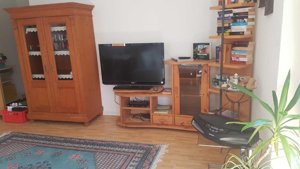 ein Wohnzimmer mit einem TV und einem Holzschrank in der Unterkunft Georgs Ferienwohnung in Michelstadt