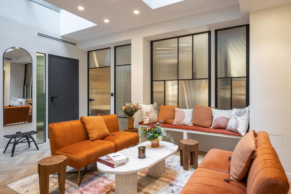 d'un salon avec des meubles orange et des fenêtres. dans l'établissement New Art Gallery Loft in the Heart of Paris 15, à Paris