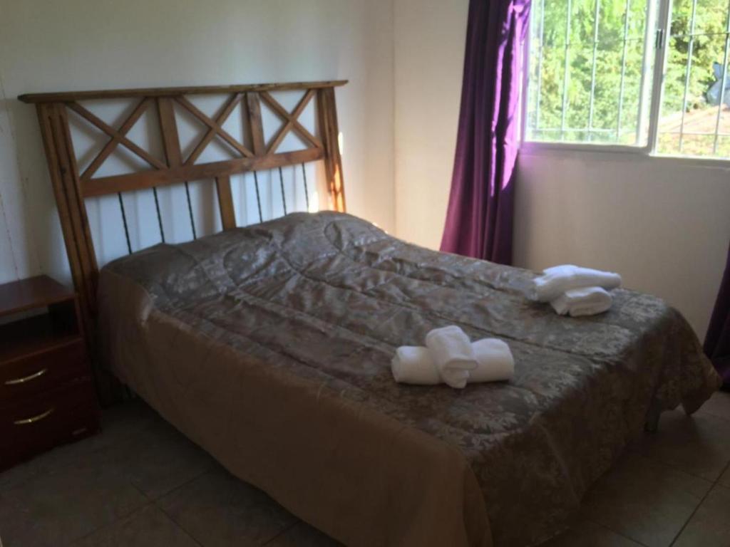 1 dormitorio con 1 cama con toallas en La Perla en Luján de Cuyo